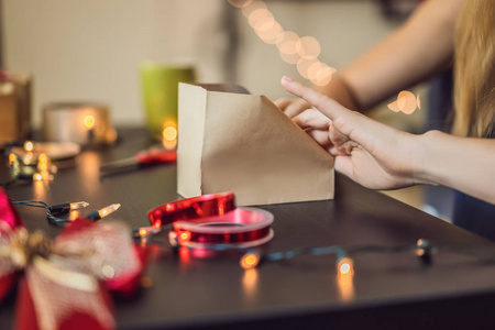 近距离观看女性包装礼物在工艺纸为圣诞节。