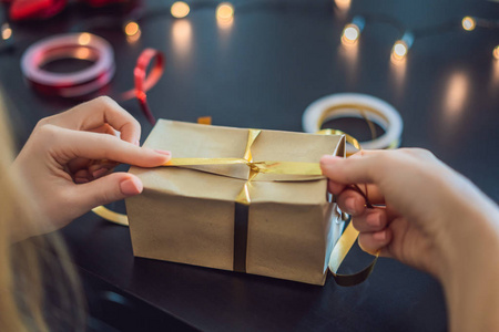 近距离观看女性包装礼物在工艺纸为圣诞节。