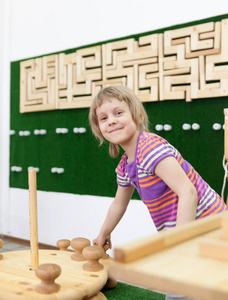 女孩在游戏室收集木制拼图。