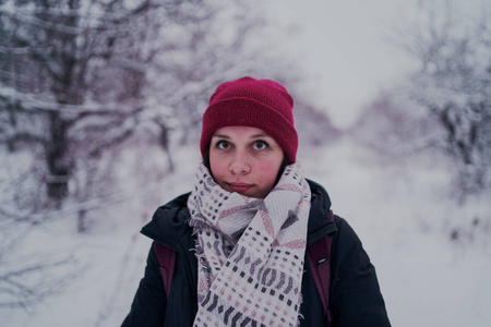 这个女孩在冬天的树林里休息。 在冬天的公园里，年轻的女人在雪地里散步