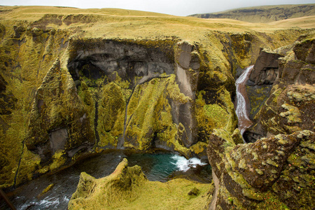 深峡谷陡峭的悬崖上长满了绿色的苔藓，周围是一条非常快的河流，有着冷水。 冰岛故事峡谷