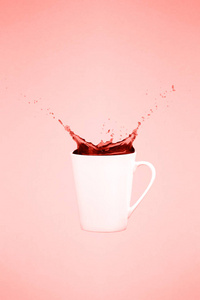 两个悬浮的咖啡杯和飞溅。 咖啡概念。 最小的艺术趋势。 坚实的背景。 垂直的。 活珊瑚主题颜色2019年