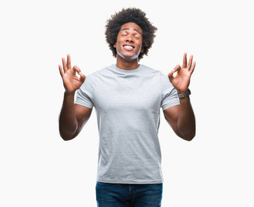 美国黑人男子在孤立的背景下放松和微笑，闭着眼睛做冥想手势与手指。 瑜伽概念。