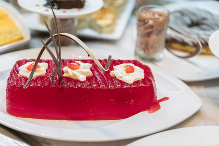 白色盘子上的餐馆里装饰着的大红果冻。