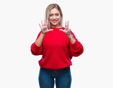 年轻的金发女人穿着冬天的毛衣，在孤立的背景上显示和举着8号手指，同时微笑着自信和快乐。