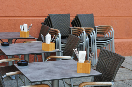 室外咖啡厅，餐具和餐巾纸放在木箱里，烟灰缸放在桌子上