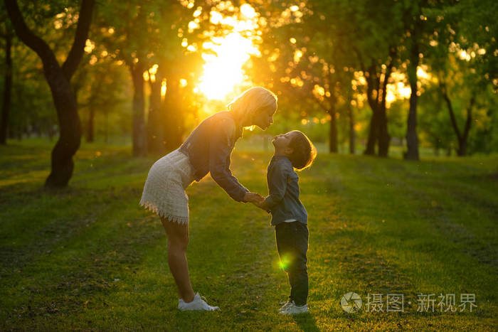 母亲和小儿子在公园或森林,在户外.拥抱,让大家一起开心