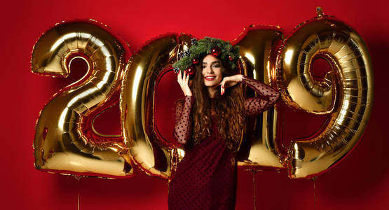 庆祝新年派对的女性对圣诞2019年的黄金气球哈哈大笑