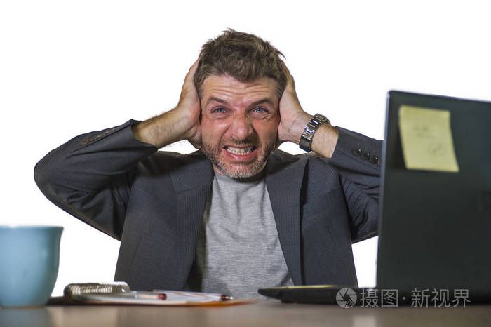 的年轻有魅力男人在办公室电脑桌工作,绝望和不知所措,感到沮丧,痛苦