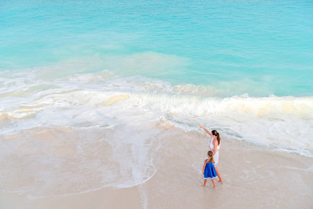 母亲和小女儿在热带海滩享受时间