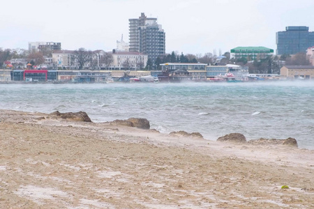 美丽的沙子和雪风暴的风景在海滩与沿海镇背景