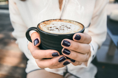 女人手里拿着一杯热茶