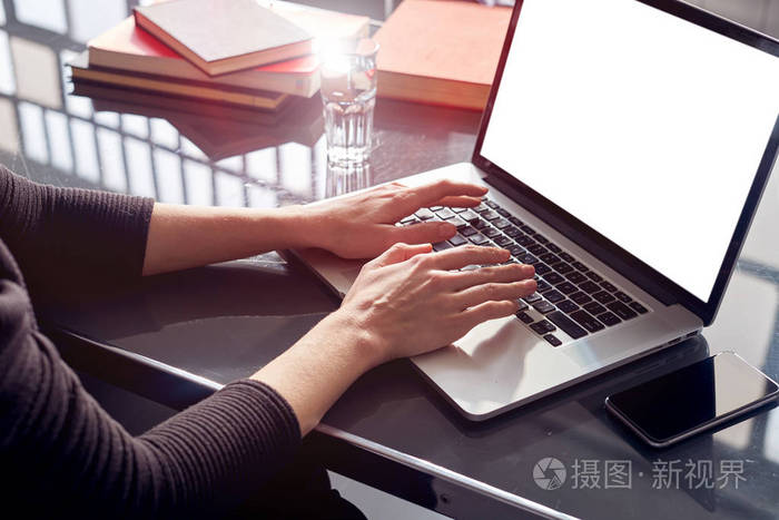 关闭商务女性手使用笔记本电脑在共同工作开放空间阁楼移动智能手机