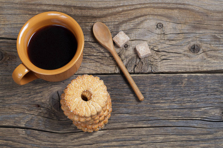 头顶望着一杯咖啡和一叠矮饼干，放在古老的木制背景上