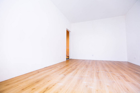 一个白色的空的斯堪的纳维亚房间内部有木制地板和墙壁的照片。家北欧内部。