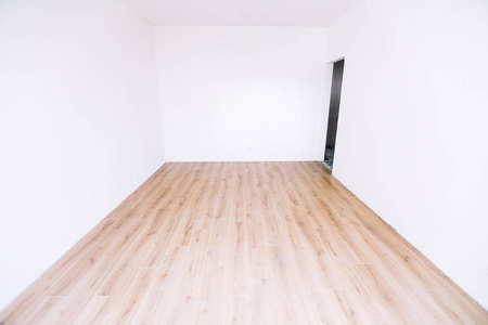 一张白色的空的斯堪的纳维亚房间内部有木地板和墙壁的照片。 家北欧内部。