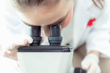 在实验室用显微镜特写年轻科学家研究的肖像。 生物技术科学化学。