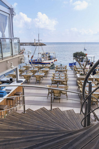 螺旋木楼梯通向希腊度假胜地赫森尼索斯海边的一家舒适的咖啡馆