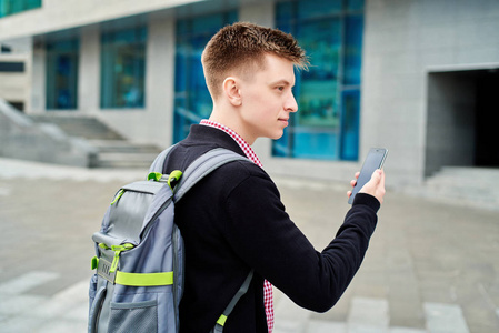 学生背包在大学校园户外行走，使用智能手机打字，上网复制空间。 技术教育概念