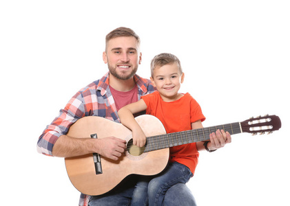 父亲教他的小儿子在白色背景下弹吉他
