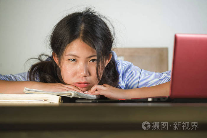 年轻的压力和沮丧的亚洲学生女孩努力工作,手提电脑和