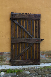 木制大门和带有砖块的橙色墙