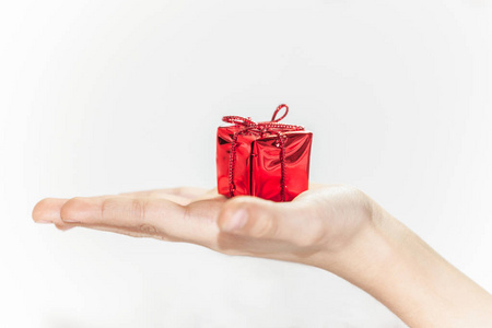 男孩手里拿着红色的小礼物盒，准备圣诞或新年