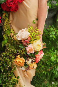 婚纱摄影一位新娘穿着丝绸婚纱，手里拿着一束美丽的大白红粉桃紫婚礼花束