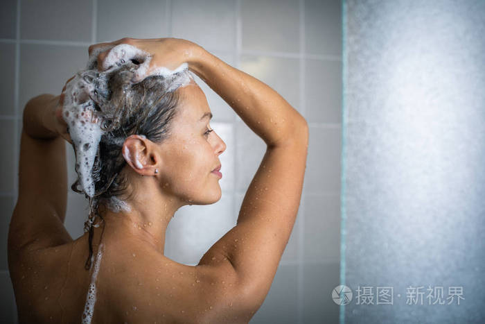 在一个现代化设计的浴室里洗头发的女人洗了一个长长的热水澡