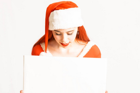 年轻漂亮的红头女孩穿着圣诞老人迷你裙，穿着中性的白色背景，有广告空间