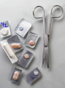 不同类型的药物与剪刀在医院的概念图像