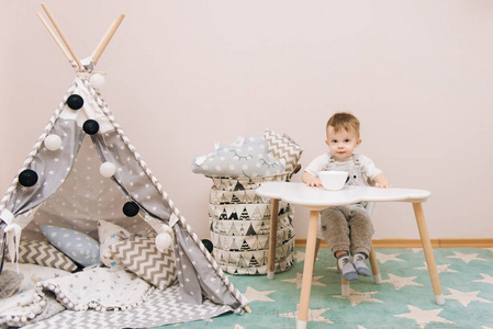 s room in white, gray and blue tones. Near the teepee and a bag 