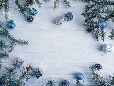 圣诞树树枝，蓝球，礼物，白色木制背景的圆锥形