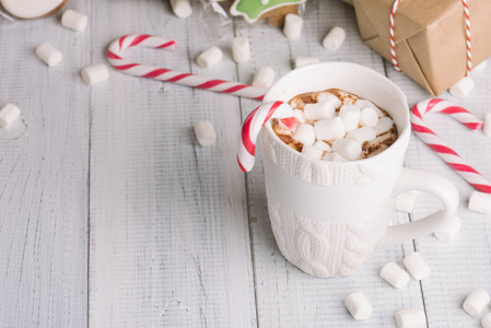 木制圣诞背景下的可可杯或巧克力。冬季热巧克力饮料，有棉花糖雪人和杉树饼干糖果罐