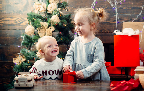 快乐的孩子们婴儿。孩子们的礼物圣诞故事概念。新年的孩子们。圣诞孩子们愉快的小孩在圣诞老人帽子与礼物有圣诞节