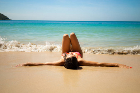 躺在蔚蓝海滩上的女孩