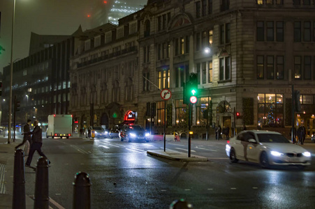 伦敦的办公室和靠近塔桥的道路在夜间展示汽车和其他建筑