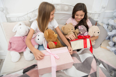 圣诞节我想要的只是礼物。快乐的小孩拿着礼品盒。床上有礼物的可爱女孩。圣诞节早上打开礼物。新年惊喜。圣诞快乐, 新年快乐