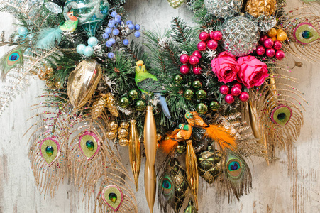 圣诞花环由松枝制成，上面装饰着孔雀羽毛玩具浆果鸟类和植物