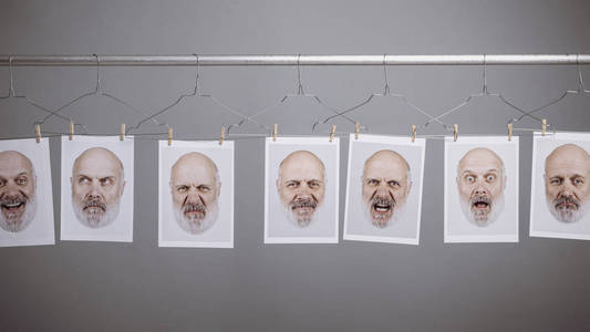 s portraits with different facial expressions hanging in line wi