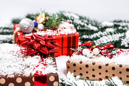 圣诞礼物与圣诞树树枝和雪的木制背景特写