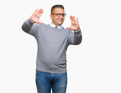 中年商务人士阿拉伯男子戴着眼镜，背景偏僻，微笑着用手手掌和手指做画框，镜头透视