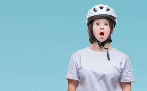 患有唐氏综合症的年轻成年骑自行车妇女戴着带惊喜表情的安全帽