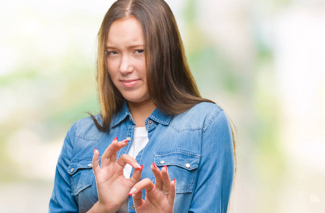 年轻的白种人美女在孤立的背景下厌恶表情，不高兴和恐惧做厌恶面对，因为厌恶反应。 举起双手。 令人讨厌的概念。