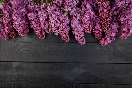黑色木制背景上美丽的丁香花束。 春天。 女人或母亲节。 伟大的卡片。 园艺概念，俯视平面布局复制空间。