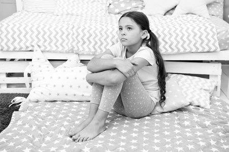 可悲的概念。可悲的小女孩。悲伤的孩子坐在床上。在家里的卧室里伤心的孩子。我想玩