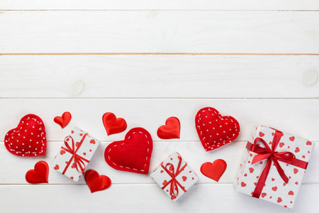 情人节或其他节日手工礼物纸与红心和礼品盒在假日包装。 现盒礼品在白色木制桌子顶部视图与复制空间空空间设计。