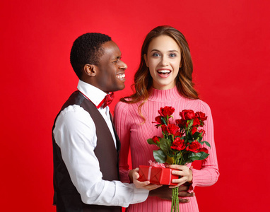 s day concept. happy young couple with heart, flowers, gift on r
