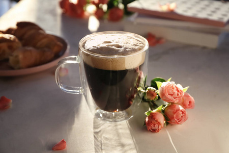一杯美味的芳香咖啡和漂亮的花放在轻桌上