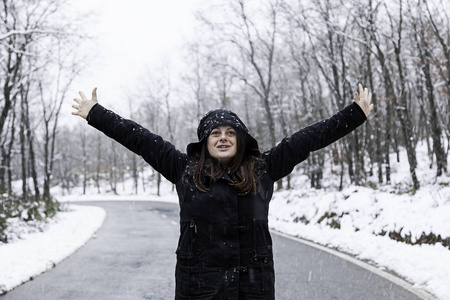 快乐的女人在雪地里的冬天和寒冷的乐趣